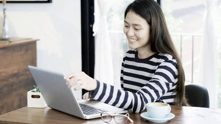 Chinese woman smiling in front of the laptop