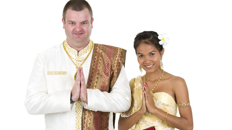 Western guy and Thai girl in traditional clothes 