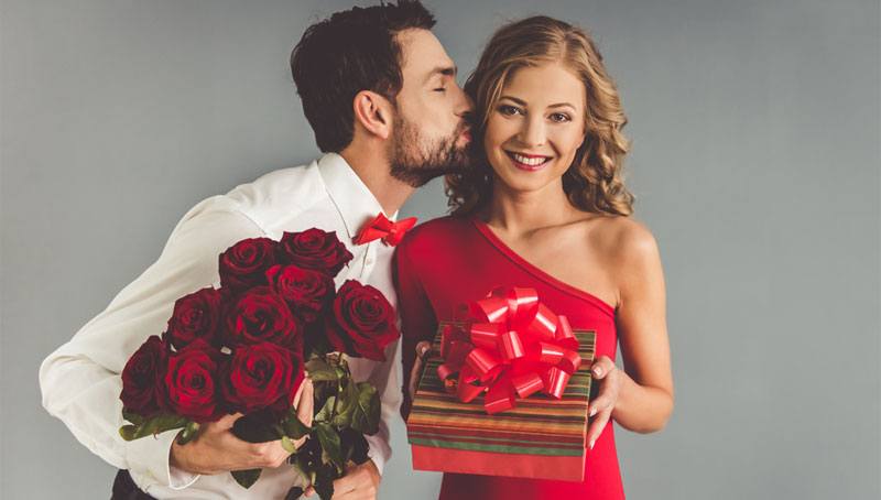 happy blonde girl receiving gift and flowers